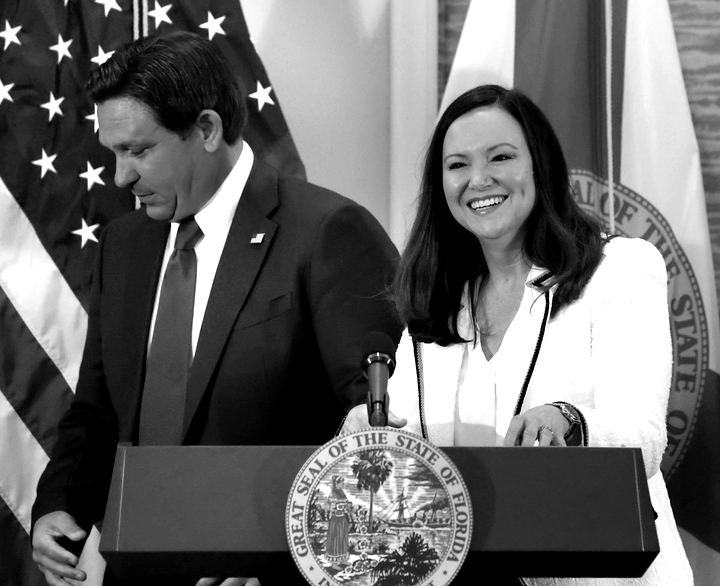 Ron DeSantis and Ashley Moody at a podium bearing the Florida state seal